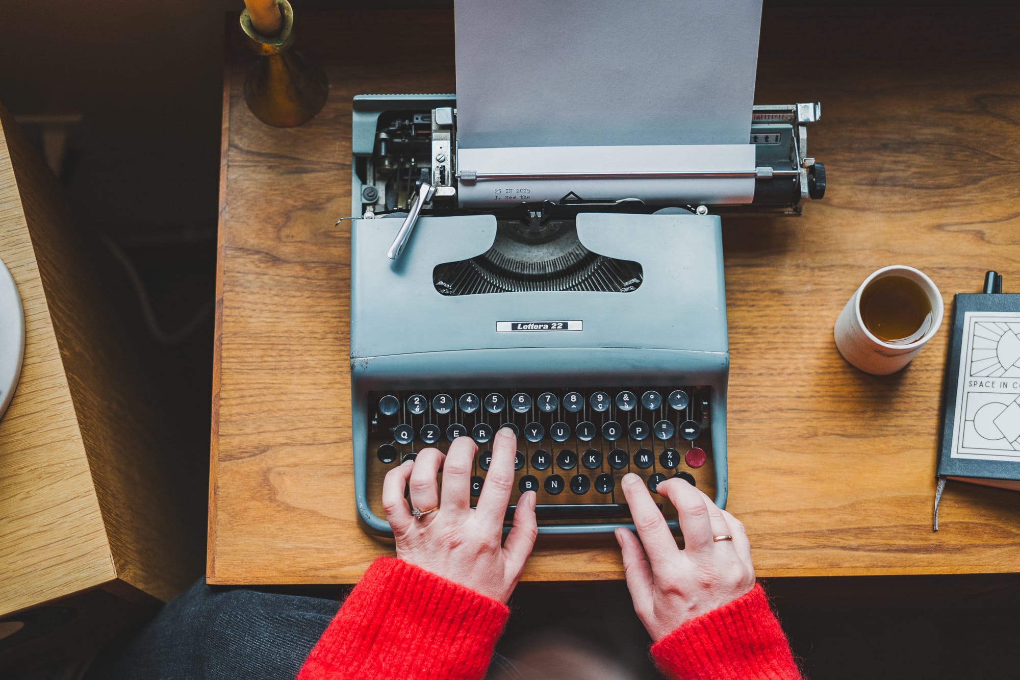 Picture taken from above of a person typing their 25 in 2025 list on a typewriter
